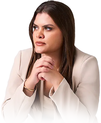 Retrato fotográfico de uma mulher jovem com cabelo escuro e maquiagem suave, usando blusa branca com mangas bufantes. Ela sorri de forma sutil enquanto olha diretamente para a câmera. A imagem tem fundo branco, iluminação suave de estúdio e composição centralizada, capturada em ângulo nível dos olhos.